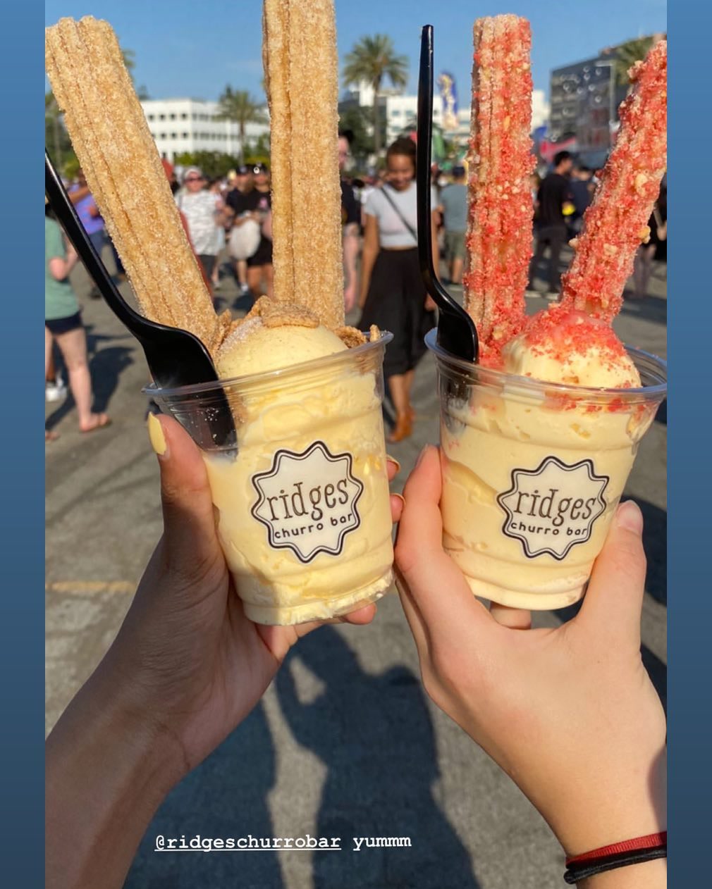 Two Ridges churro sundaes — cinnamon and strawberry — held up at an outdoor festival.
